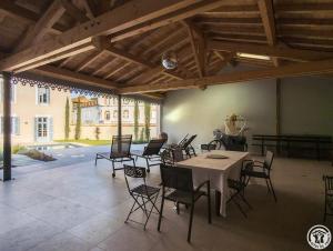 a room with a table and chairs and a building at La villa saviesa in Cazères