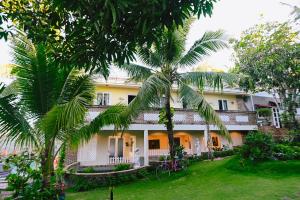 a house with palm trees in front of it at Veranda Resort Phan Thiết in Tiến Thành