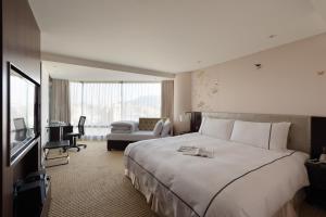 a hotel room with a large bed and a desk at K Hotel Taipei Dunnan in Taipei