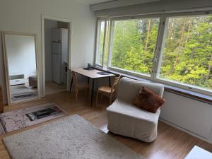 a living room with a chair and a table and windows at Style studio in Lohja in Lohja +17 photos
