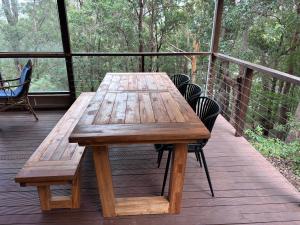 a wooden table and chairs on a deck at The Perch in Nornalup
