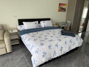 a bedroom with a bed with a blue and white comforter at New world condo1802 in Rayong