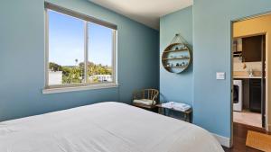 a blue bedroom with a bed and a window at Stimson Coastal Luxury by AvantStay in Pismo Beach