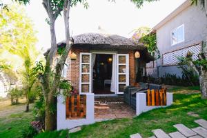 a small house with a bench in the yard at Veranda Resort Phan Thiết in Tiến Thành
