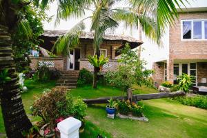 a house with a palm tree in the yard at Veranda Resort Phan Thiết in Tiến Thành