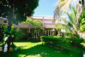 a building with palm trees in front of a yard at Veranda Resort Phan Thiết in Tiến Thành +155 photos