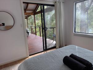 a bedroom with a bed and a large sliding glass door at The Perch in Nornalup