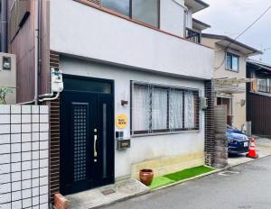 a house with a black door on a street at Guesthouse Nara IROHA in Nara