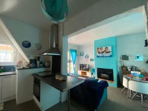 a kitchen with a table and a blue wall at Maison de pêcheurs les petits quinquins in Étaples +12 photos