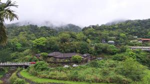 a house on the side of a mountain with a bridge at Hometown Yashe in Tung-kua-liao
