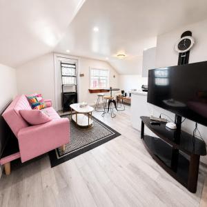 a living room with a pink couch and a flat screen tv at Jeddore Lodge in Head of Jeddore