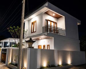 a white house at night with lights on it at MEDEWI BREEZE House in Airsatang