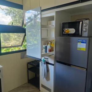 a refrigerator with a microwave on top of it at Villa Bosque - Forest Residences in Antipolo