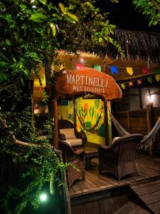 a restaurant with a hammock and a sign on a deck at Martinelli Residence in Fernando de Noronha