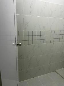a shower with a glass door in a bathroom at Middle Road Hostel in Nathon Bay