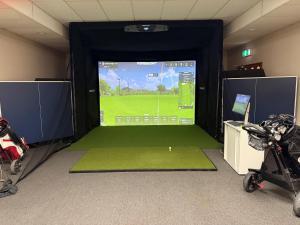 a room with a golf game on a screen at Central Park Motor Inn in Taumarunui