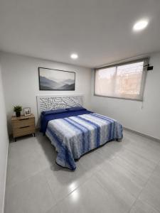 a white bedroom with a bed and two windows at Havana House in Mexico City