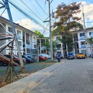 a street with cars parked in front of buildings at Villa Bosque - Forest Residences in Antipolo