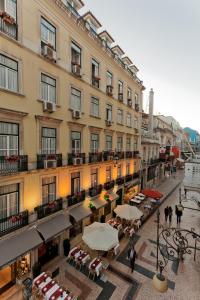 an empty street with tables and umbrellas in front of a building at Residencial Florescente in Lisbon