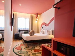 a hotel room with a bed and a tv at Ibis Styles Madrid Airport Valdebebas in Madrid +182 photos