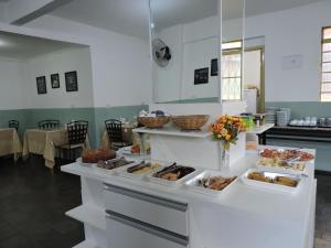 a kitchen with a counter with different types of food at Hotel Galli in Campo Grande