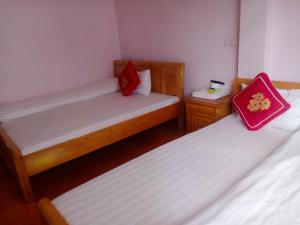 a room with two beds with red pillows on them at Kiên Cường Hostel in Sapa