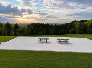 two picnic tables sitting on a concrete slab in a park at Overlook Mountain Inn in Guntersville