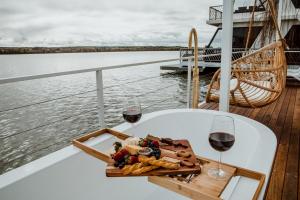 a plate of food and two glasses of wine on a boat at The Floathouse - Floating tiny home on the Murray in White Sands