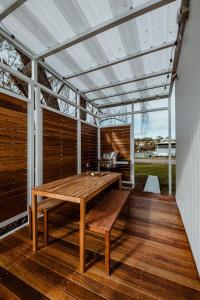 a patio with a wooden table on a deck at The Floathouse - Floating tiny home on the Murray in White Sands