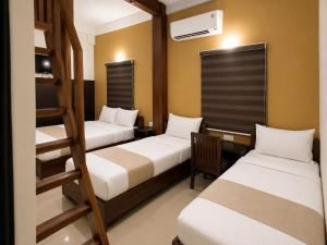 a room with two beds and a bunk bed at Nova North Inn in Cochin +18 photos