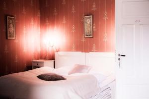 a bedroom with a large white bed with red wallpaper at Visnes Hotel Stryn in Stryn