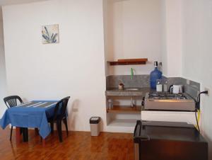 a kitchen with a stove and a table with chairs at Refugio de Daye in Puerto Ayora +29 photos