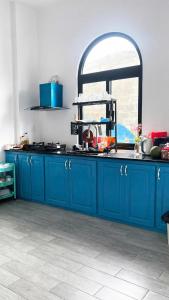 a kitchen with blue cabinets and a window at Dứa Homestay in Cu Lao Thu