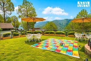 a table and chairs and umbrellas in a yard at Sirmour Baag by Vaana - A part of StayVista in Nahna