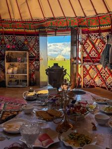 a table with plates of food in a tent at Yurtcamp Rahat&Horse Trekking in Kyzylemgek