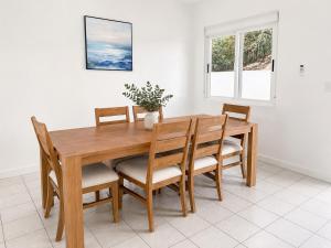 a wooden dining room table with chairs and a vase on it at The View at Green Cay - Full AC - Walk to the Beach in Christiansted +8 photos