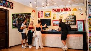 a group of people standing at the counter of a restaurant at Pariwana Hostel Lima in Lima