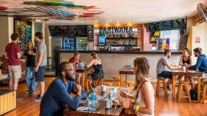 a group of people sitting at tables in a restaurant at Pariwana Hostel Lima in Lima