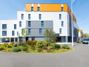 a large white building with a parking lot at ibis Styles La Rochelle Centre les Minimes in La Rochelle
