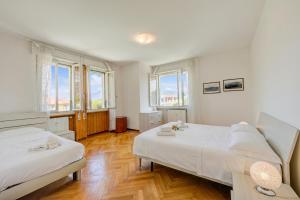a bedroom with two beds and two windows at Margherita near lake - Family Friendly - Happy Rentals in Toscolano Maderno