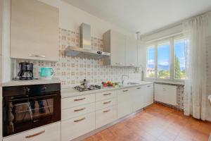 a kitchen with white cabinets and a large window at Margherita near lake - Family Friendly - Happy Rentals in Toscolano Maderno