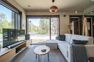 a living room with a white couch and a large tv at Levi Platinum Aurora in Levi