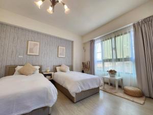 ein Schlafzimmer mit zwei Betten und einem Fenster in der Unterkunft PiR2 House in Tainan