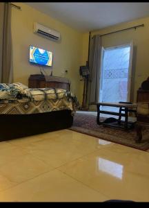 a room with a bed and a table and a window at Pyramids Heritage suites in Ghaţāţī