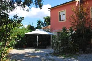 a house with a table and an umbrella in front of it at Appartamenti Mare in Marina di Campo