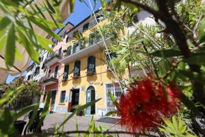 a yellow building with a red flower in front of it at Affittacamere in Piazzetta in Sarzana