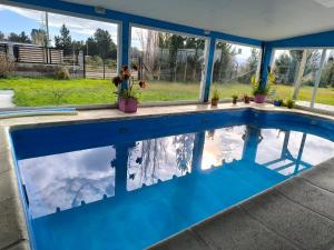 a swimming pool with a reflection of the sky in the water at Alojamiento Amado in Los Antiguos