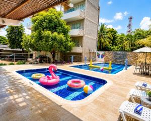 a swimming pool with two inflatables and a swimming pool at Apartasuite tolu in Tolú