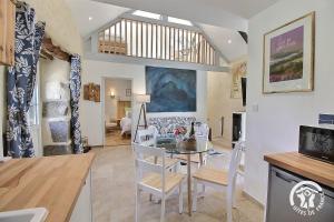 a kitchen and dining room with a table and chairs at Le murmure des oiseaux in Plussulien