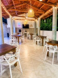 a restaurant with wooden tables and white chairs at Apartasuite tolu in Tolú